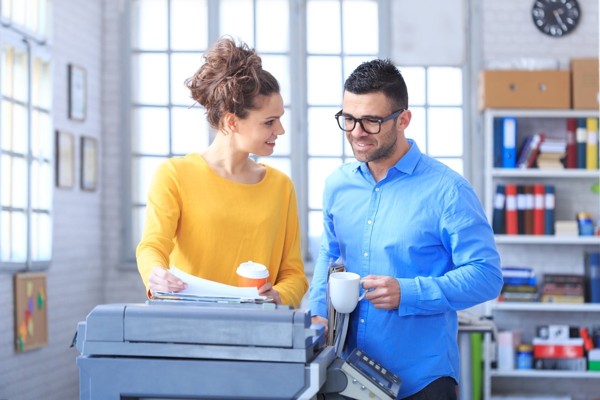 Two People Doing Same Thing in Office