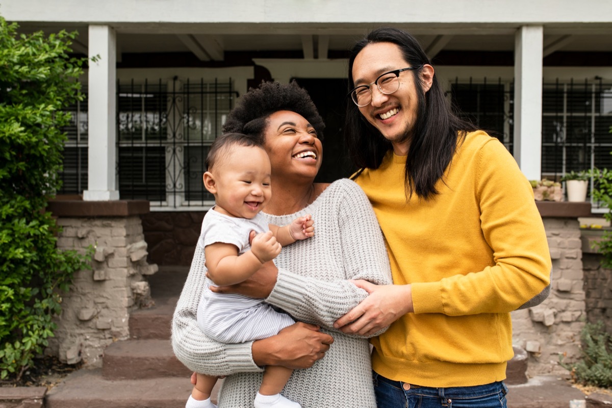 happy family standing outside their home