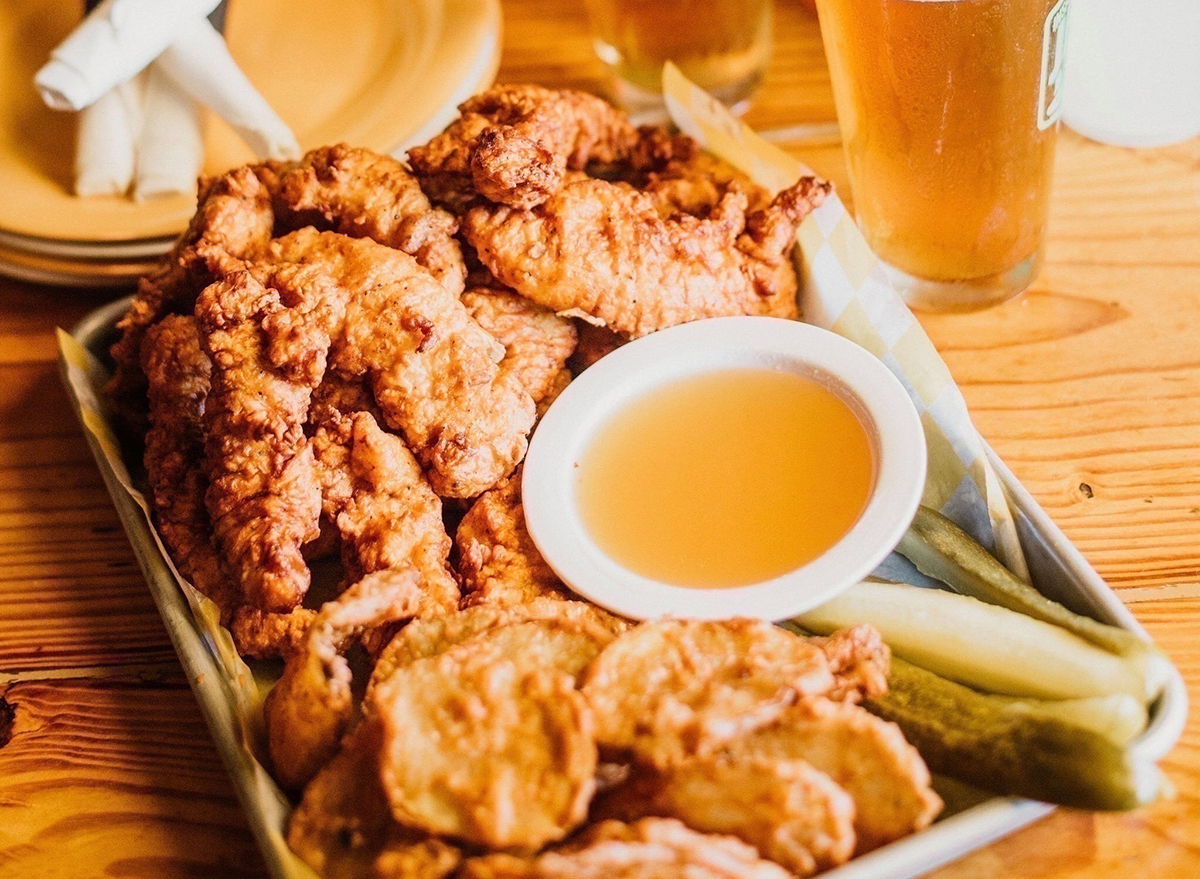 plate of chicken tenders with dip and pickles