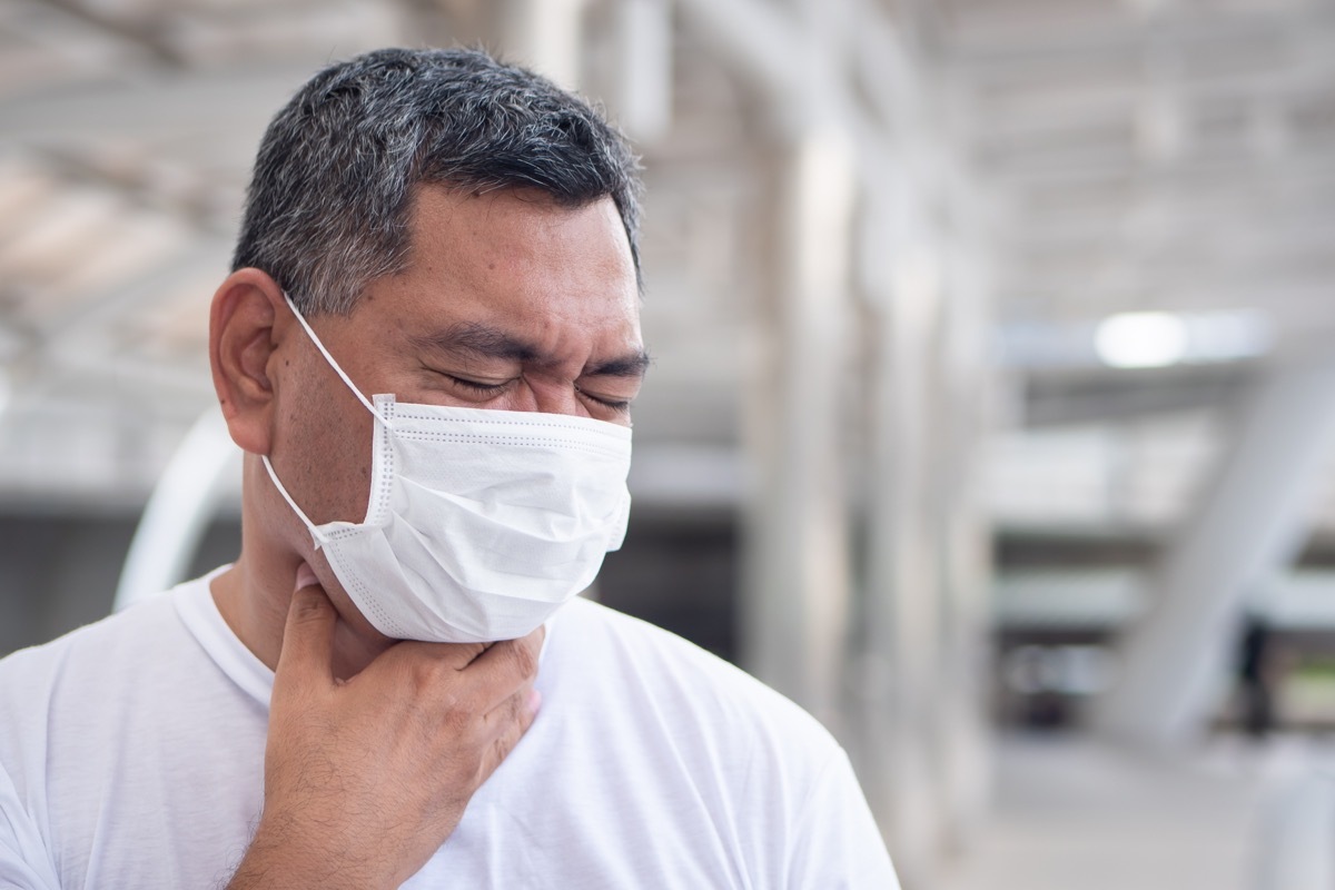 man experiencing hiccups holding throat