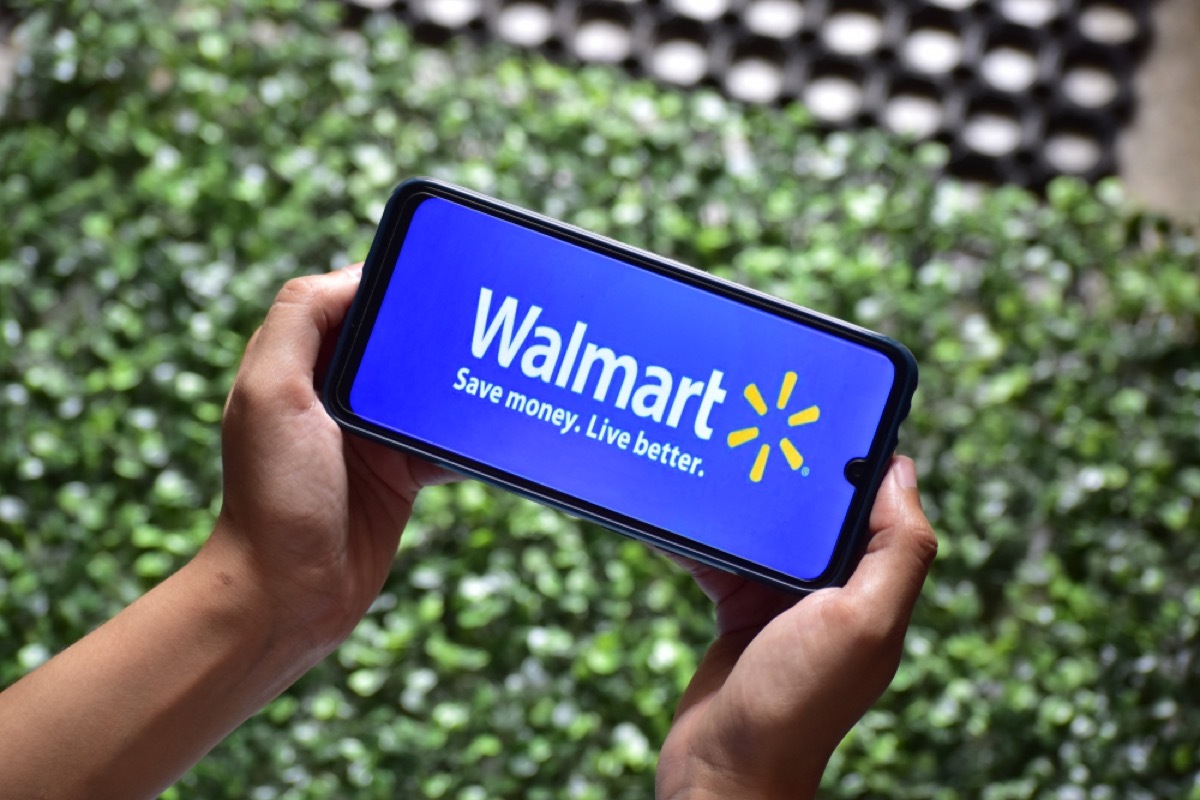 two hands holding a phone with the walmart app up on it