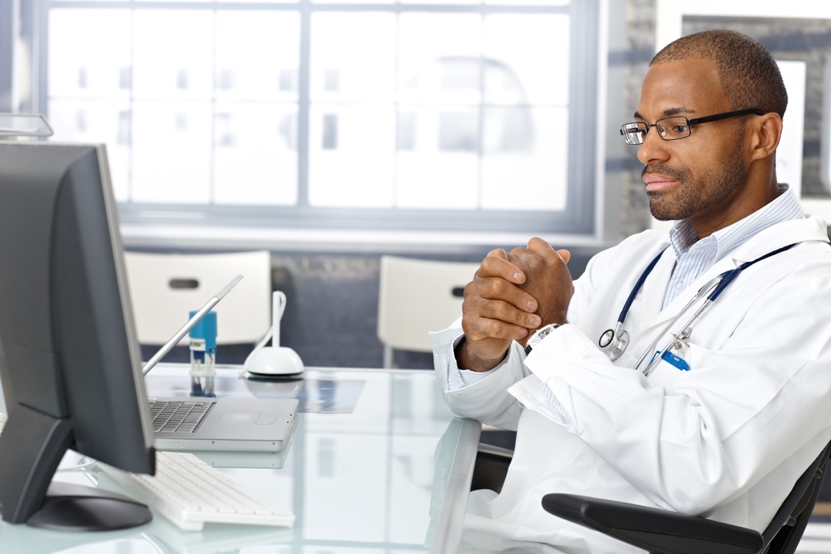 doctor sitting at desk, worried, thinking hard