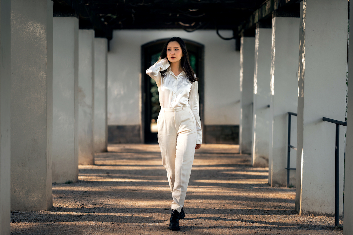 Woman walking down a promenade wearing all white with black shoes