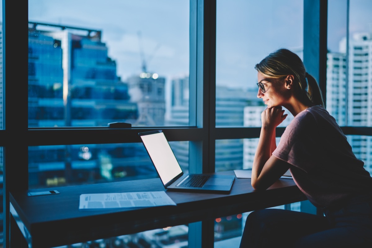 woman looking at laptop in dark