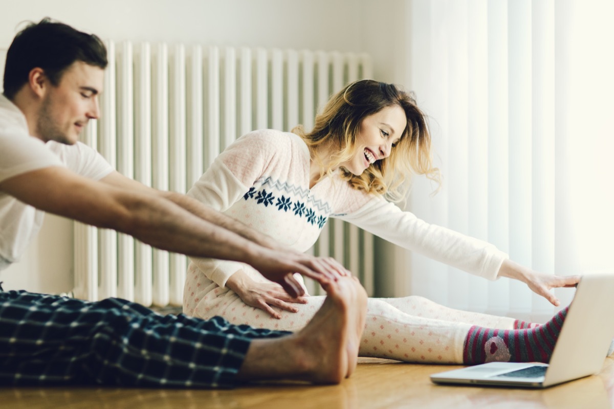 Happy couple doing stretches and working out at home