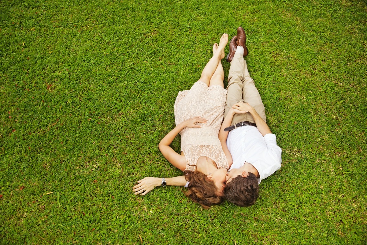 Young man and woman cuddling in grass