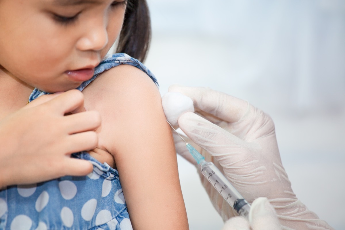 young asian girl getting shot or vaccine from doctor