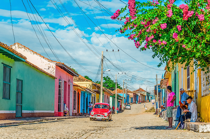 colorful buildings and a vintage car on a street in cuba