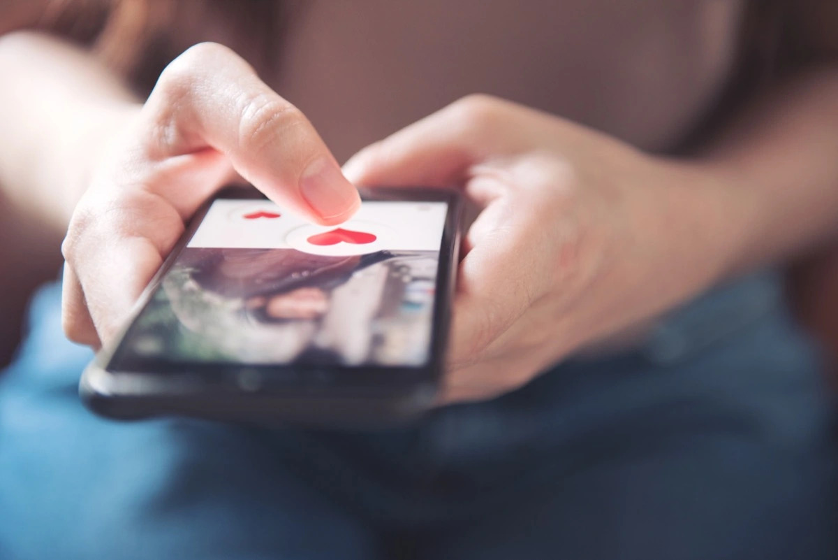 Woman liking dating app profile on phone