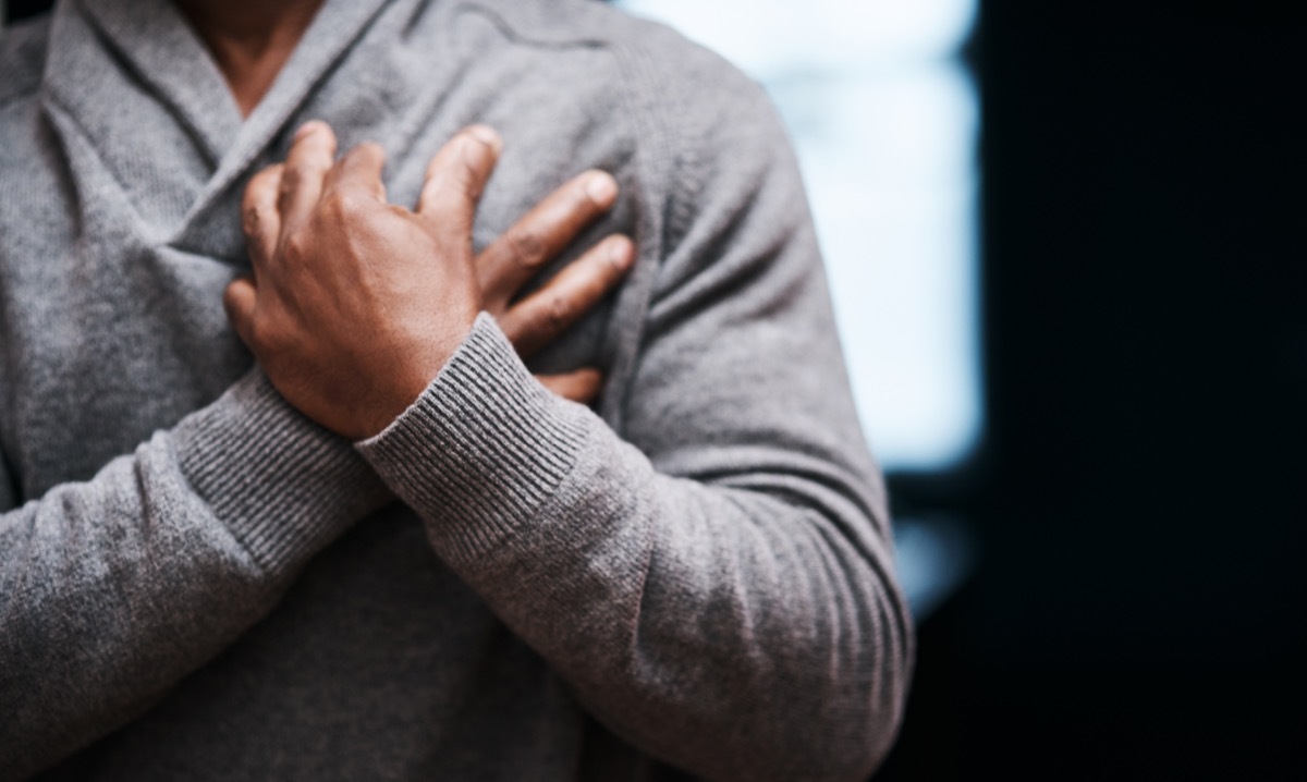 Shot of an unrecongizable man holding his chest in pain indoors