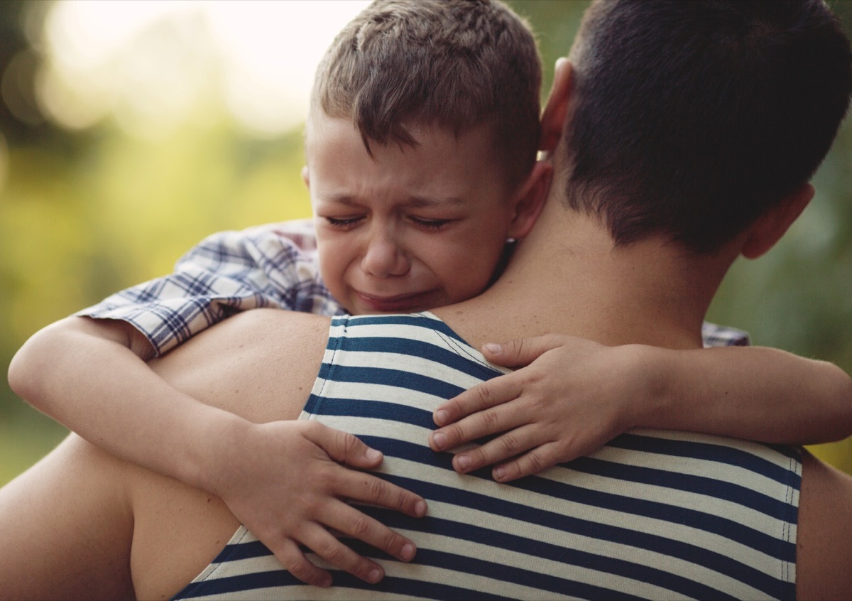 crying boy hugging dad