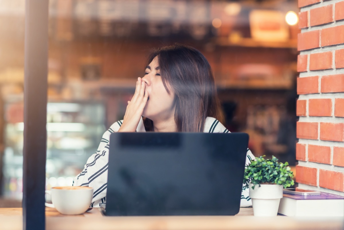 Woman yawning at laptop