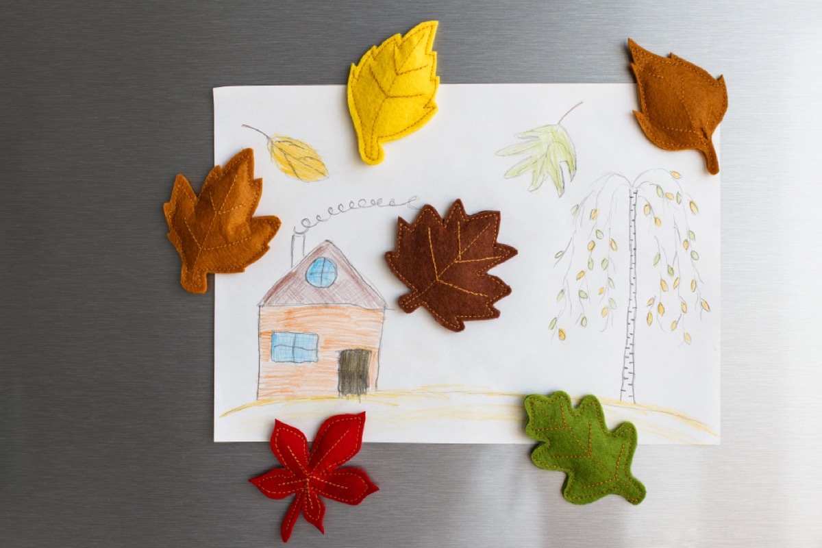 stainless steel refrigerator with kids drawing on it and leaf magnets