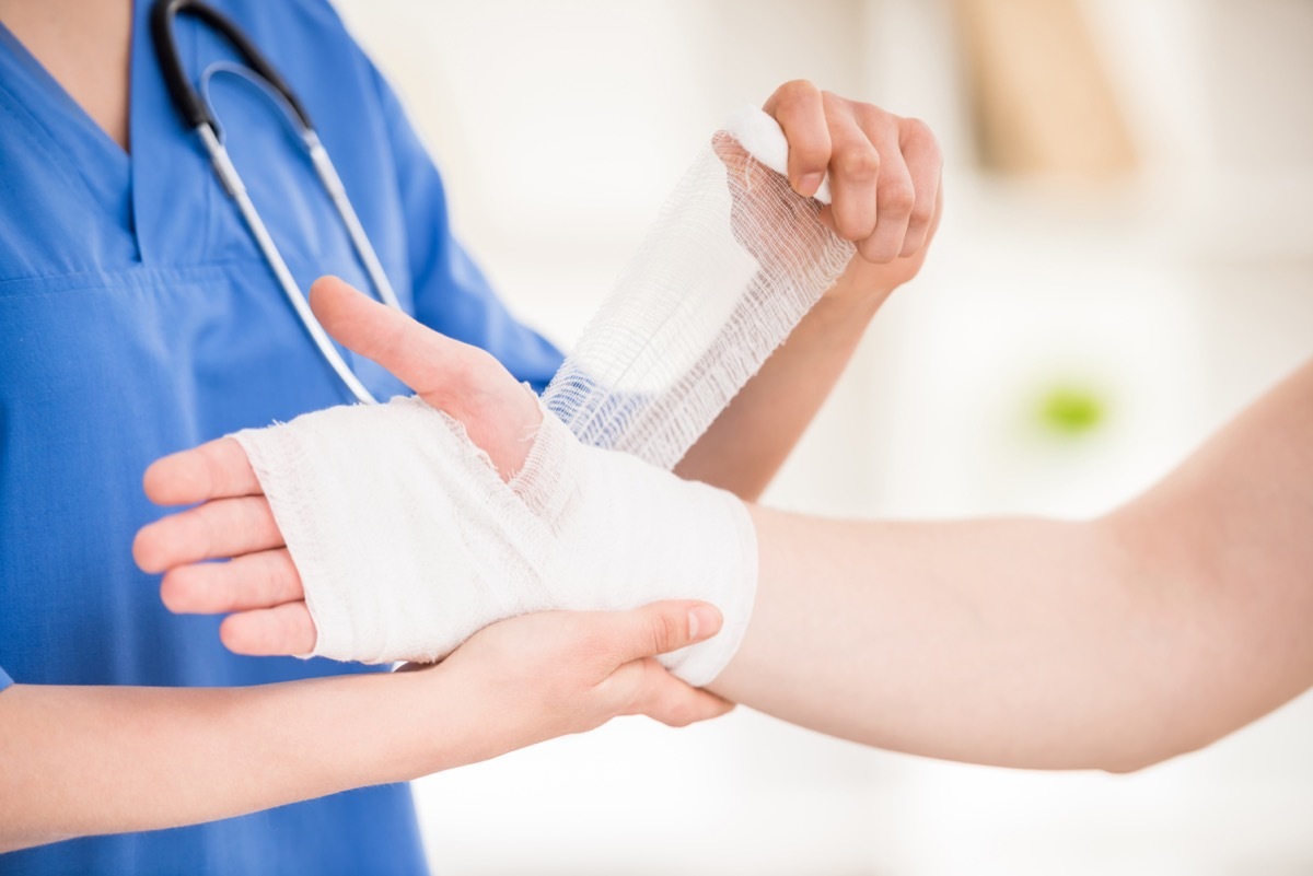 doctor bandaging person's hand