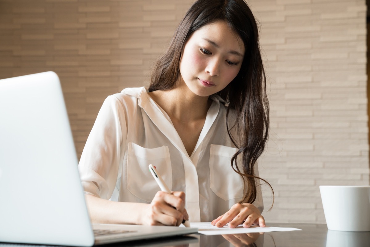 asian woman signing a form