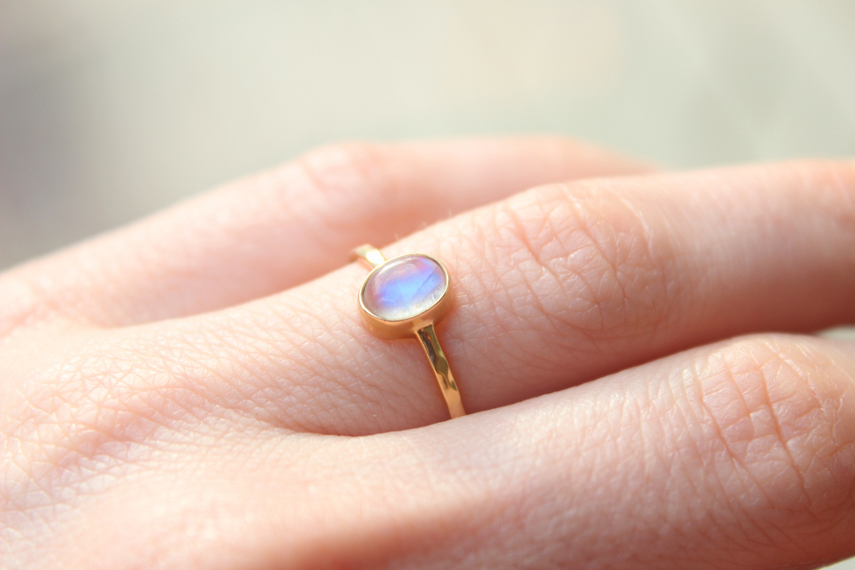 Gold moonstone ring on female hand.