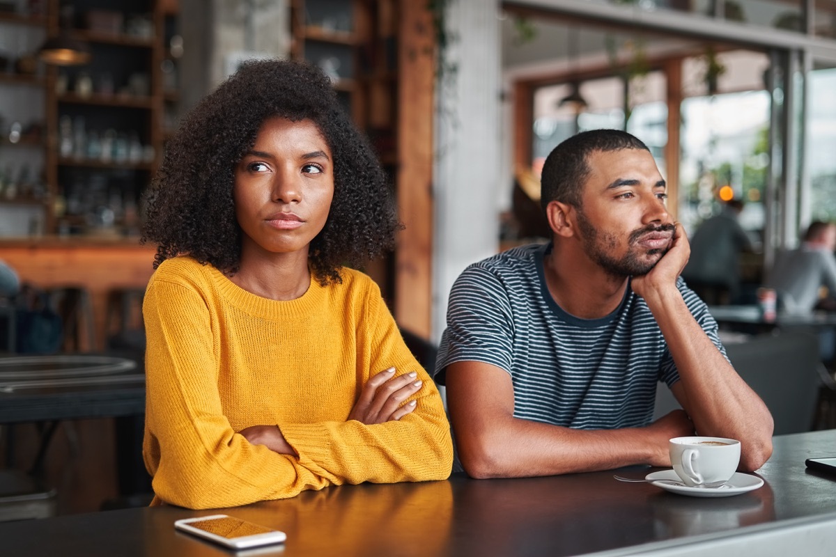 An angry and sad couple after quarrel sitting in cafe