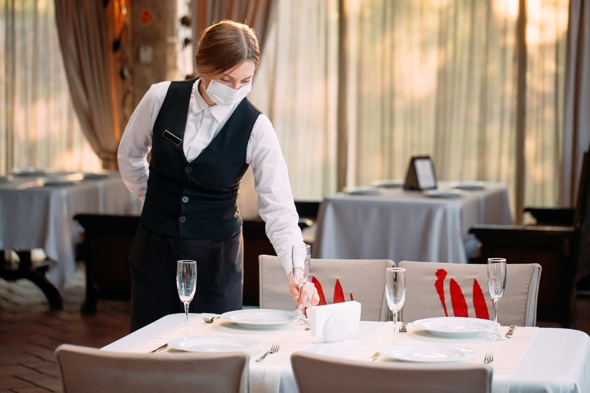 Waitress wearing mask in restaurant