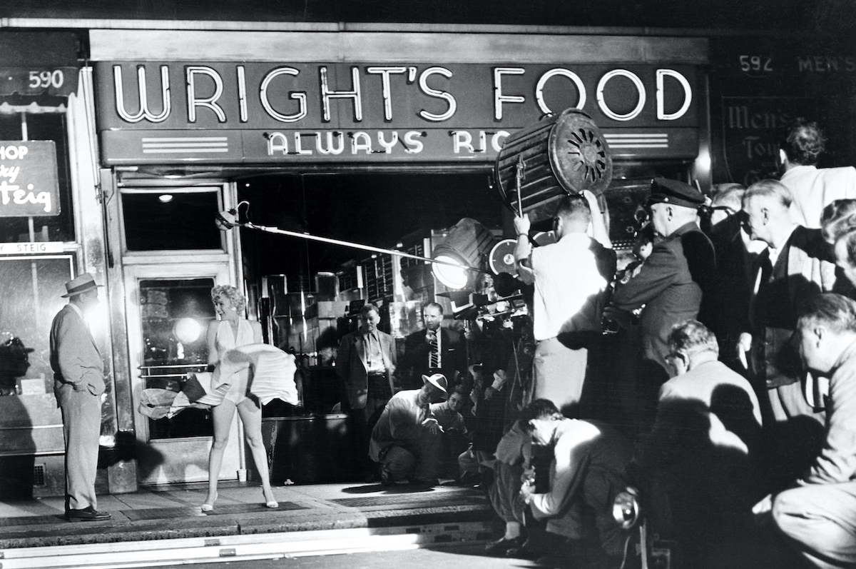 Scene outside a food store at 51st Street and Lexington Avenue early today as Marilyn Monroe stood over a subway grating and had her skirts blown up by a giant blower while talking to Tom Ewell in a scene from the movie they're making of the famed stage play 