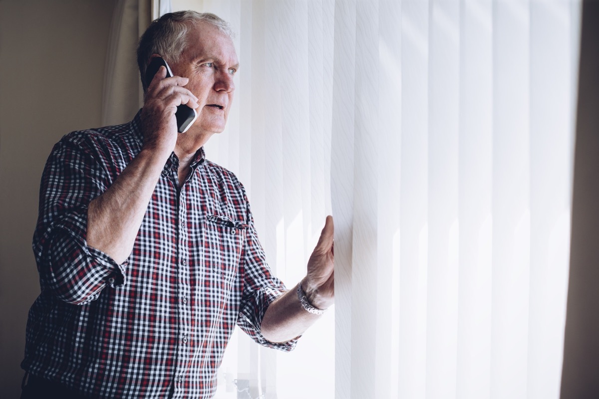 Man Looking Out His Window in Fear Police Officer Secrets