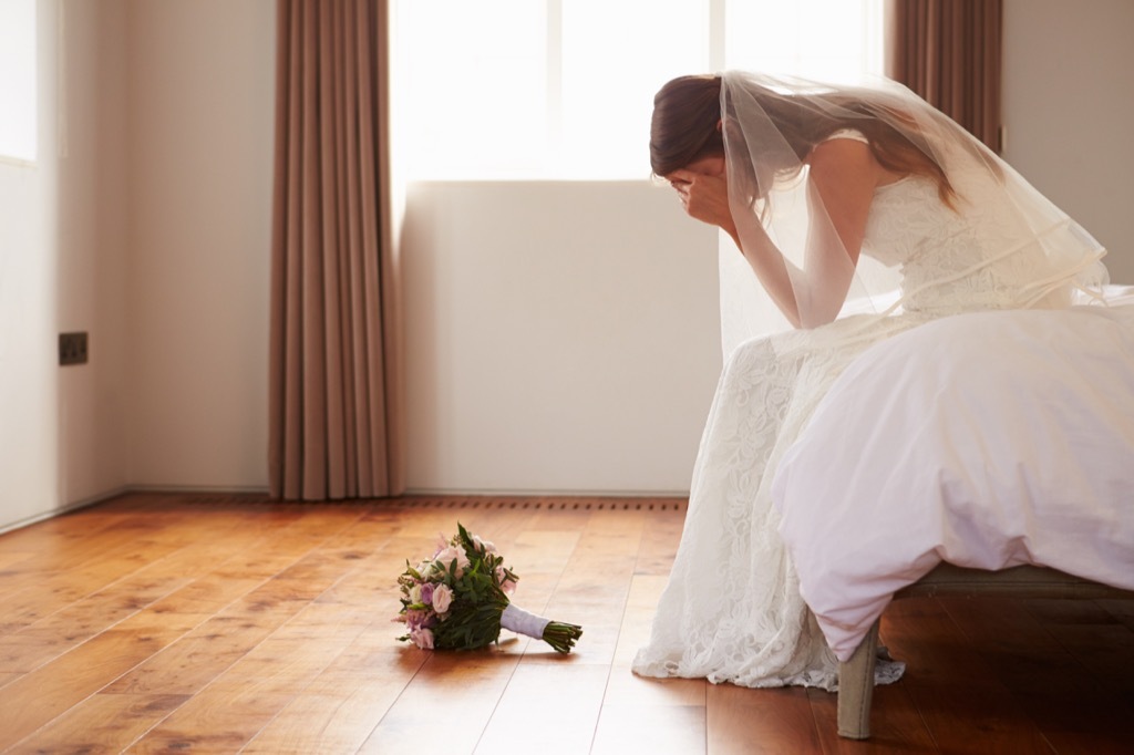 Sad bride with head in her hands