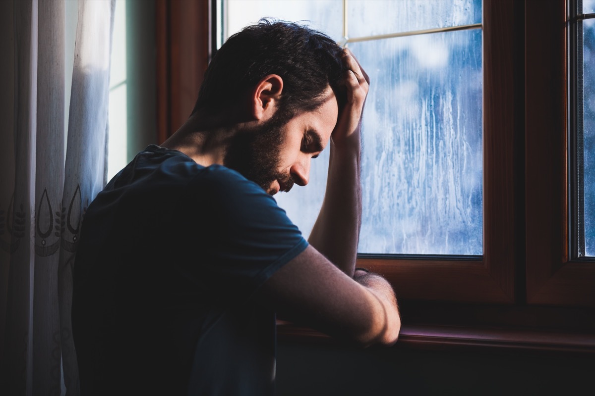 Man looking sad by a window