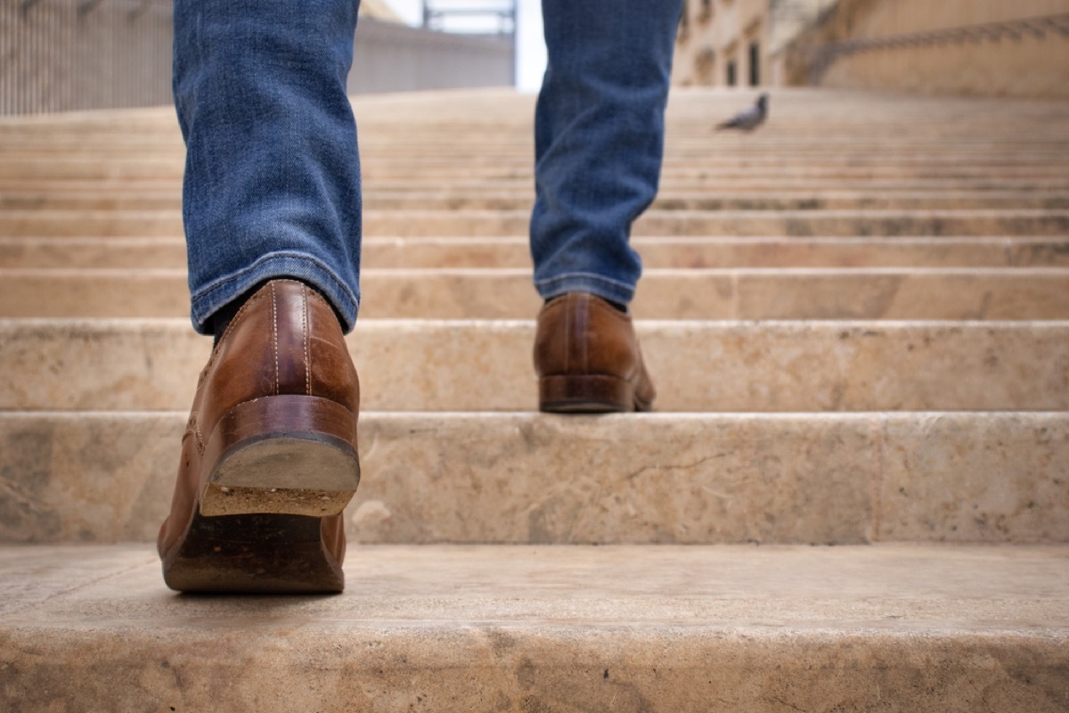 close up of man's legs walking up stairs