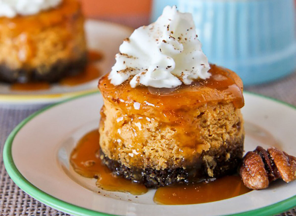 mini pumpkin cheesecake with gingersnap crust and pecan and whipped cream on plate