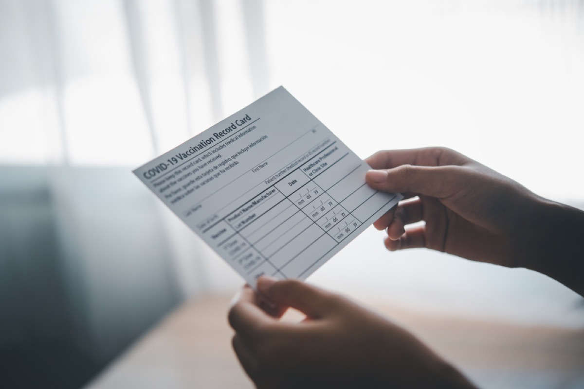 close up of person holding covid vaccination card