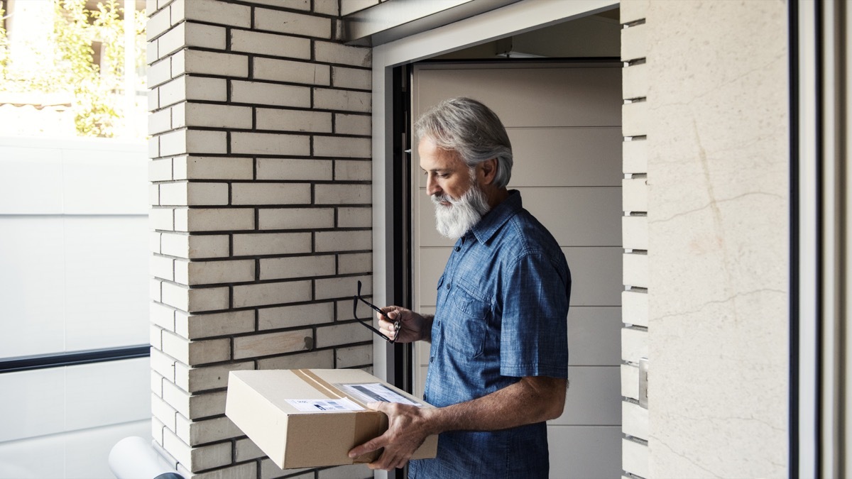 Mature man customer receiving parcel post box Sign signature by smartphone