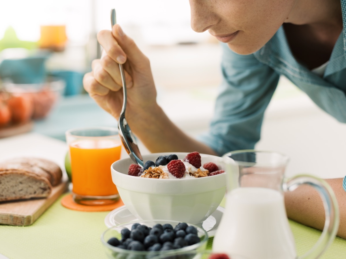 woman eating yogurt with berries