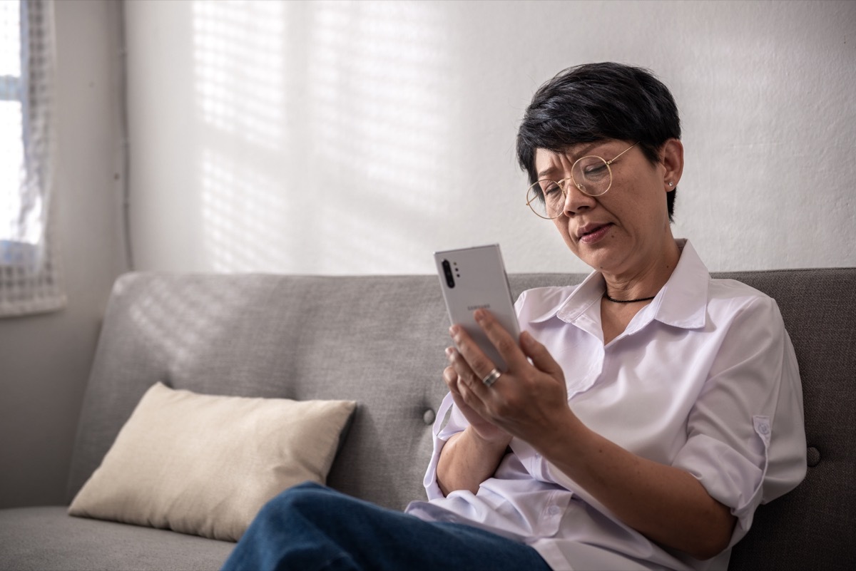 older woman dialing smartphone