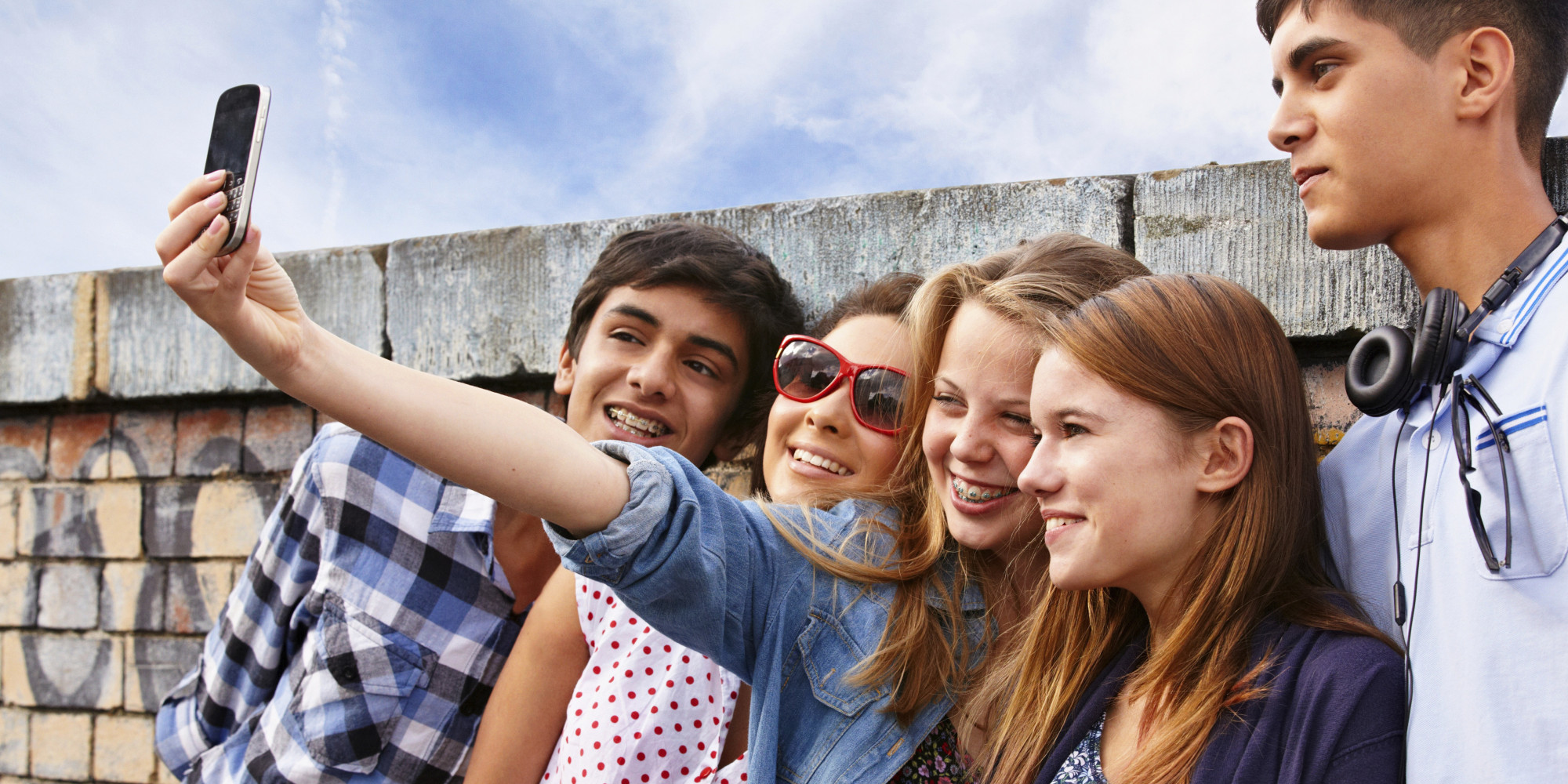 Teenage friends photographing themselves with smartphone