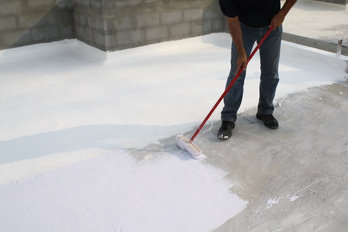 man painting roof