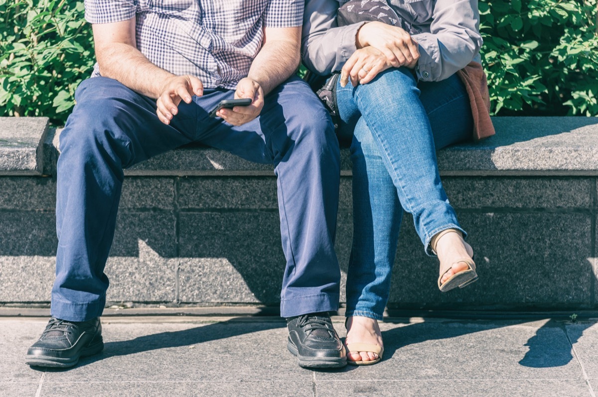 man giving no room to woman beside him