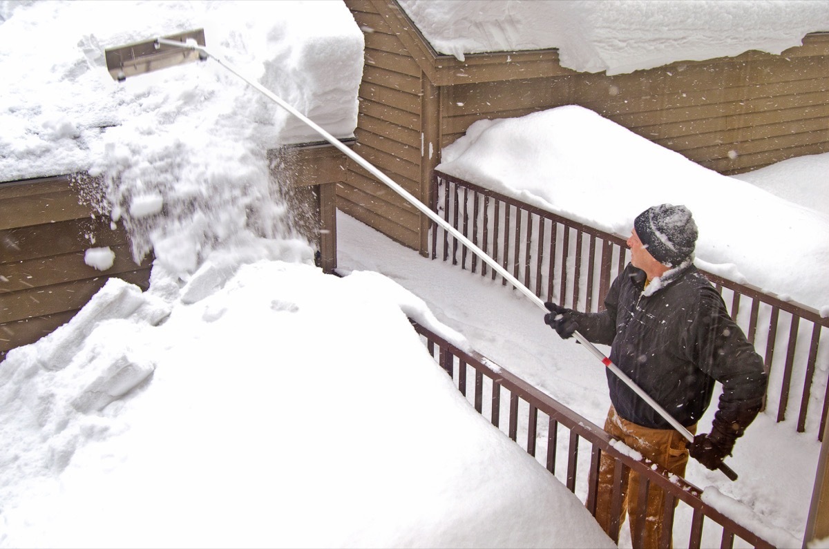 Man Using a Roof Rake on the Snow {How To Winterize a Home}