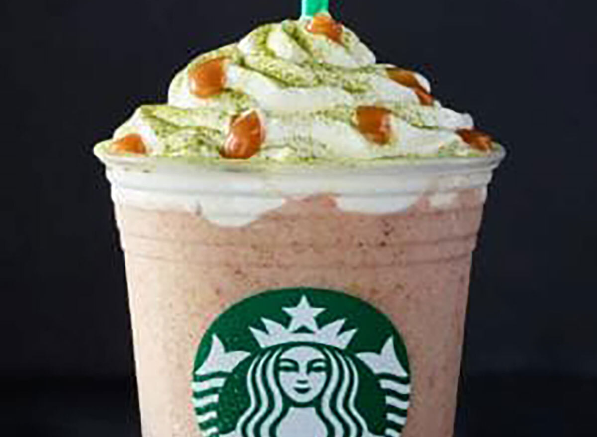 starbucks fruitcake frappucino in disposable plastic cup on black background