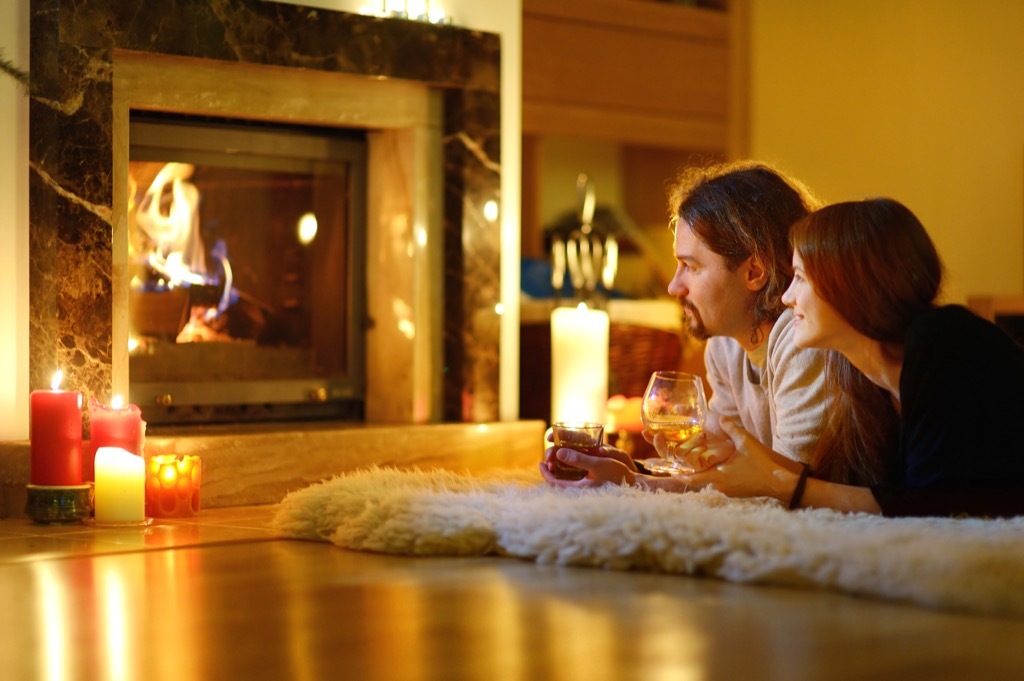 couple by the fireplace and candles at home, date night ideas