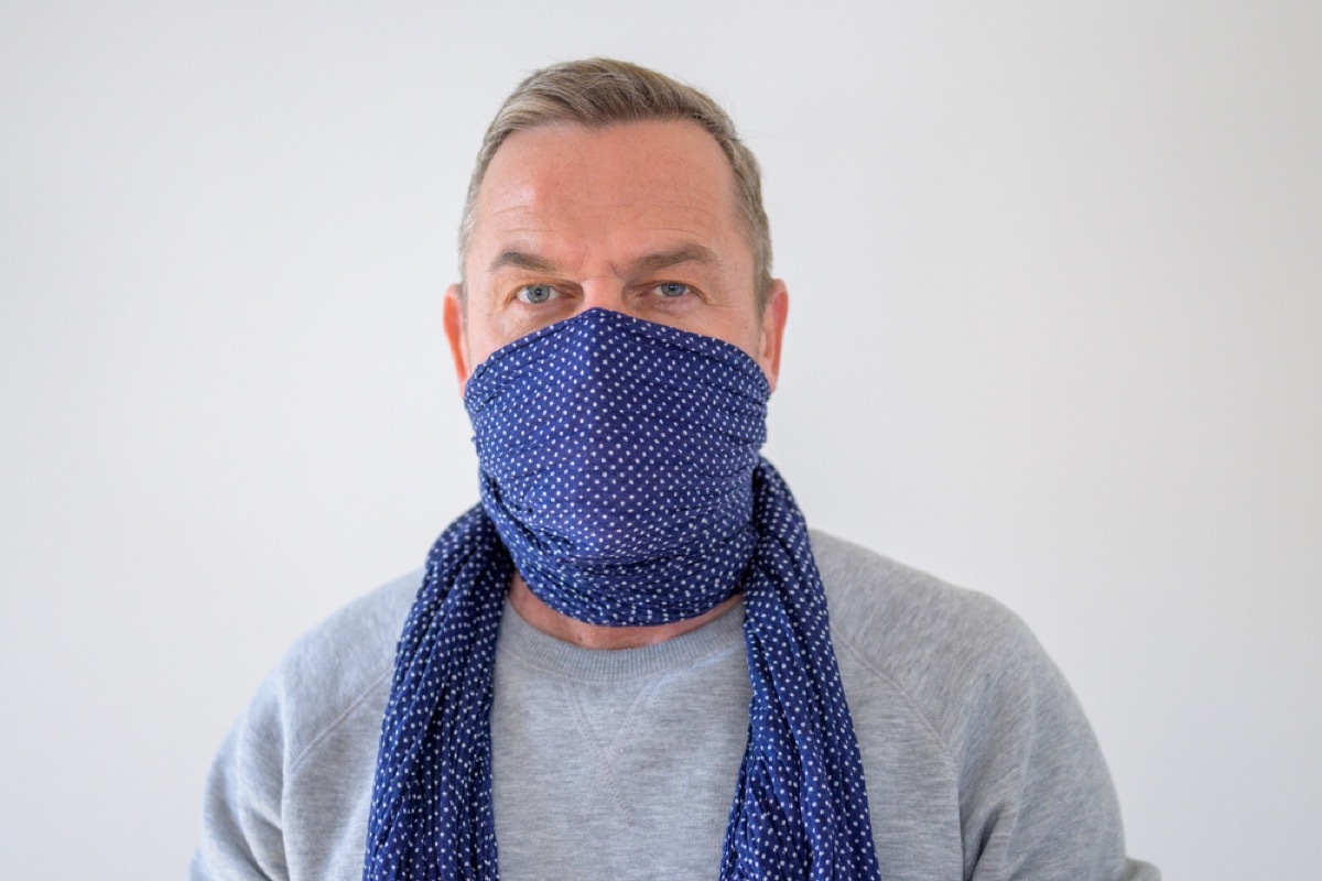 older white man wearing scarf as face covering