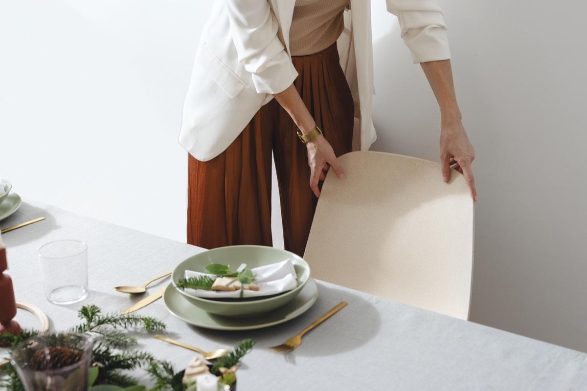 woman pulling chair out from table