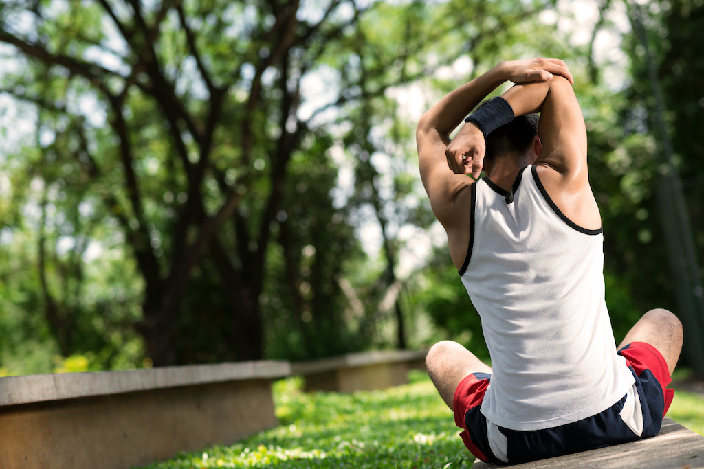 man stretching with a sweatband on his wrist {Health Mistakes}