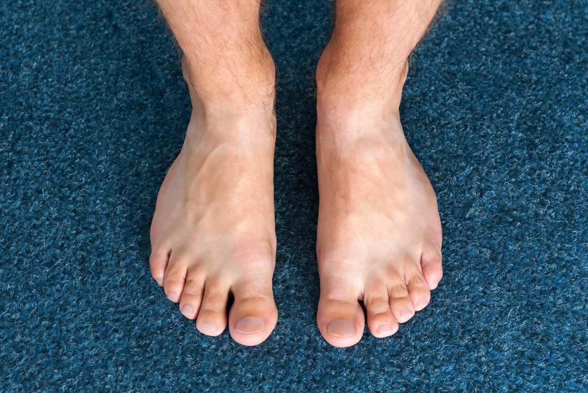 man's bare feet on blue carpet