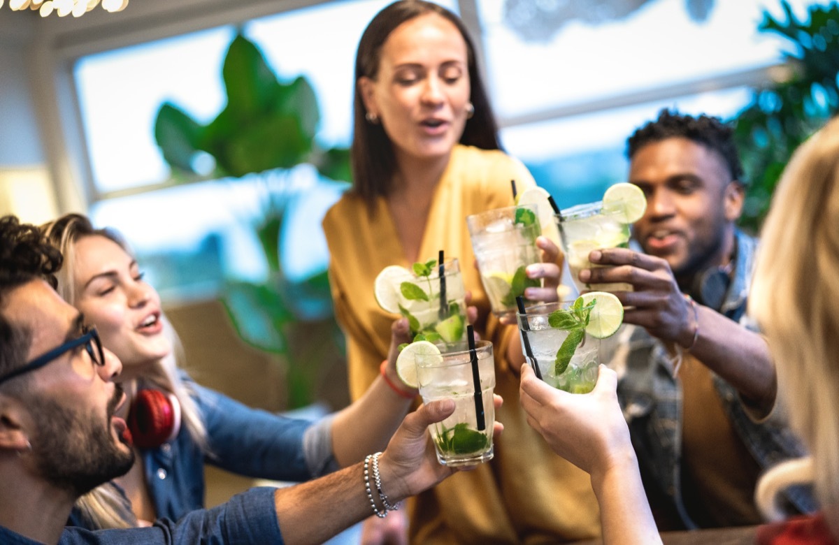 group of friends making a toast with cocktails