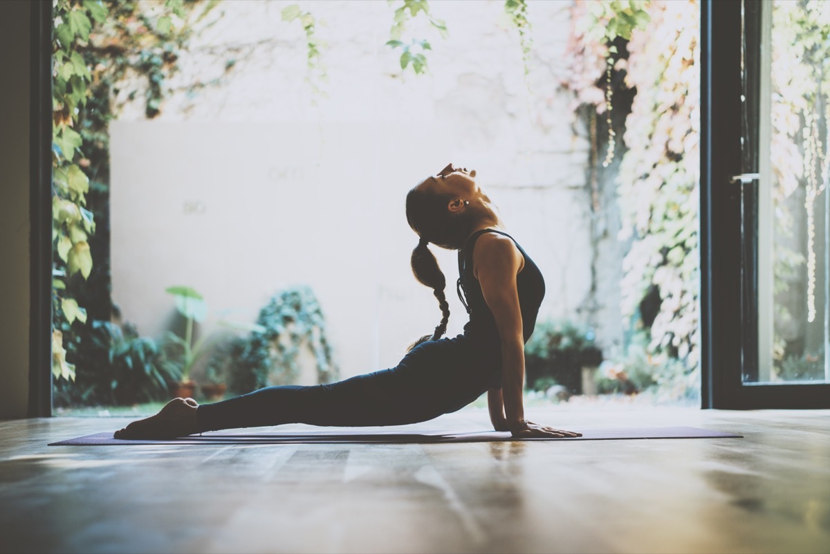 Woman stretching her back in cobra pose doing yoga