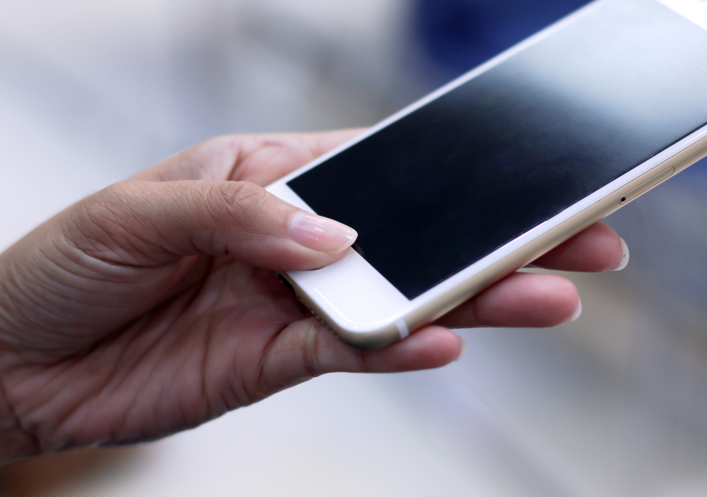 Woman Using Fingerprint Scanner on Smartphone