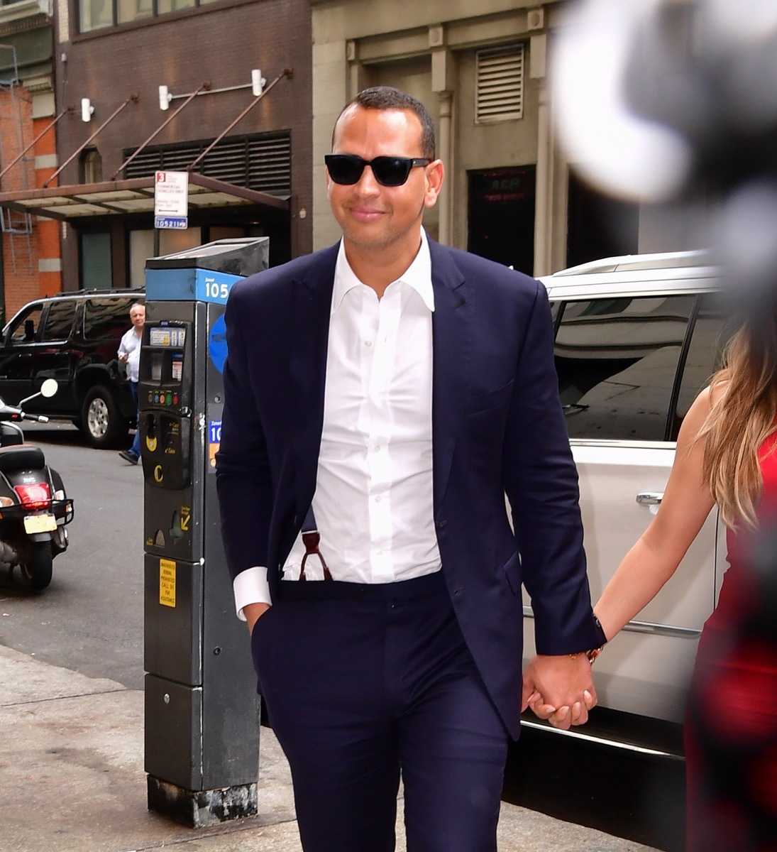 alex rodriguez walking outdoors in blue suit and sunglasses