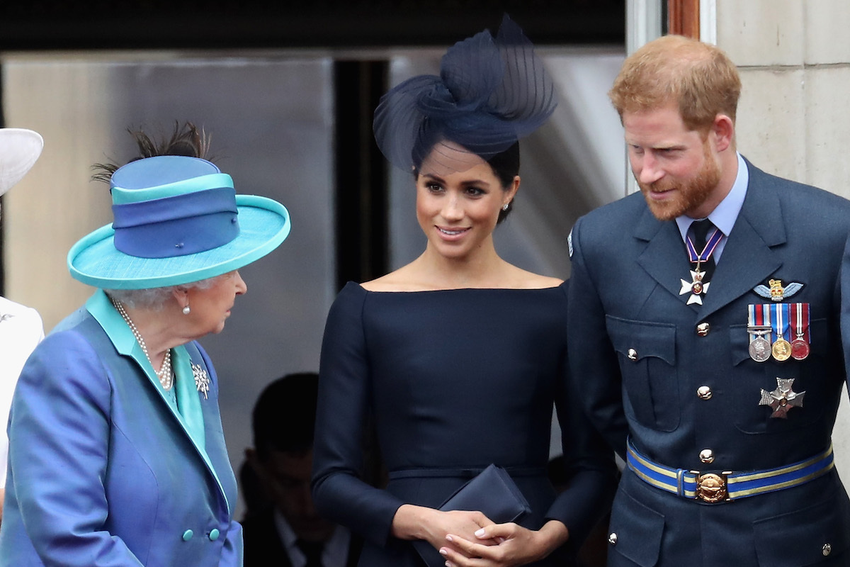 Queen Elizabeth II, Meghan, Duchess of Sussex, Prince Harry, Duke of Sussex watch the RAF flypast on the balcony of Buckingham Palace