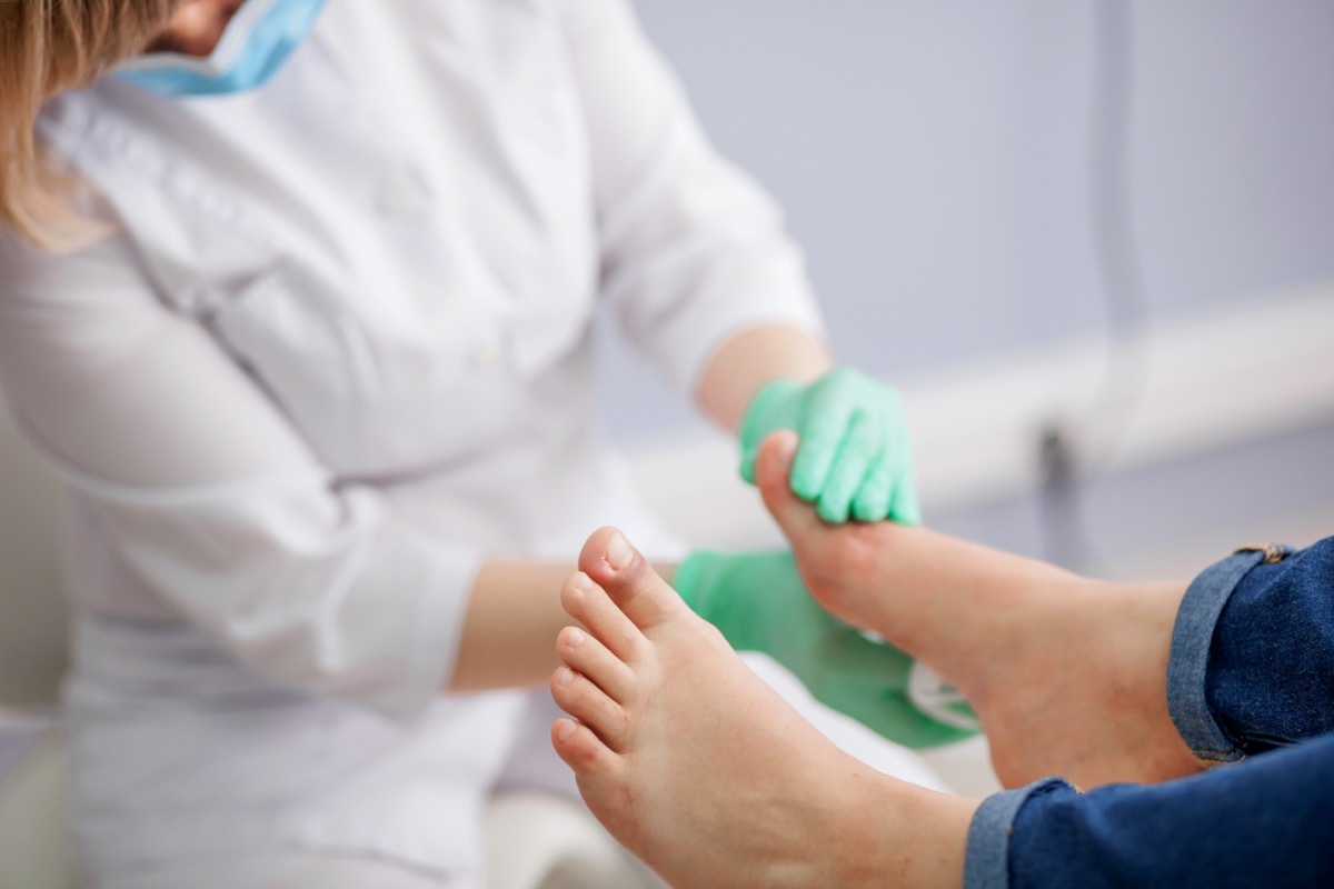 doctor, the podiatrist examines the foot