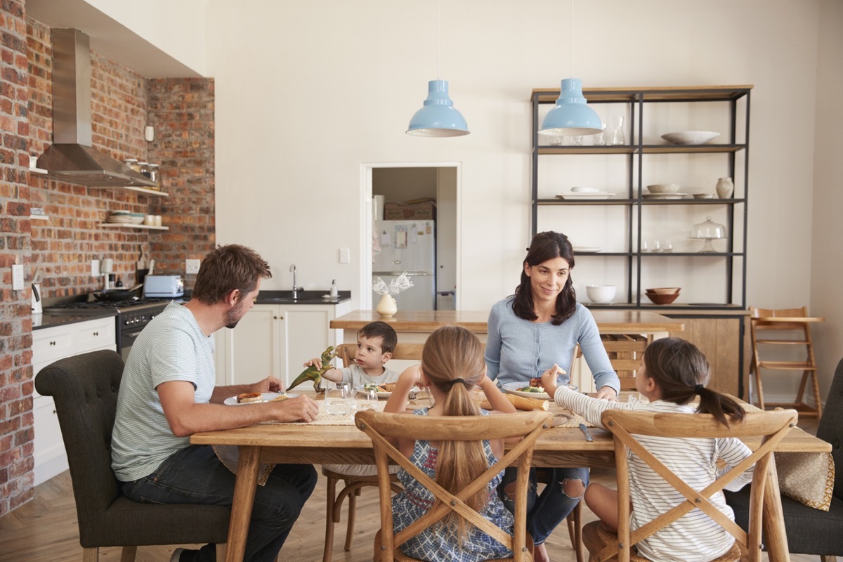 Family Eating Meal In Open Plan Kitchen Together