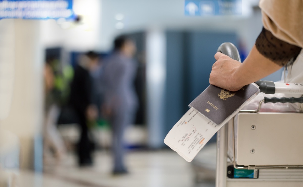 girl holding passport and boarding pass